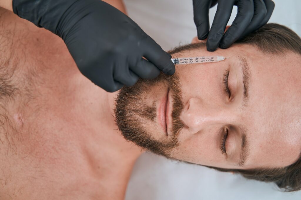 Male patient receiving a face filler injection